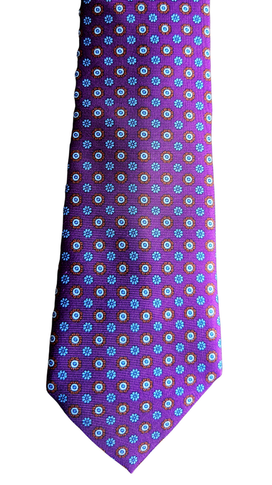 A purple necktie with a repeating pattern of small white and green floral motifs, shown flat against a plain white background.